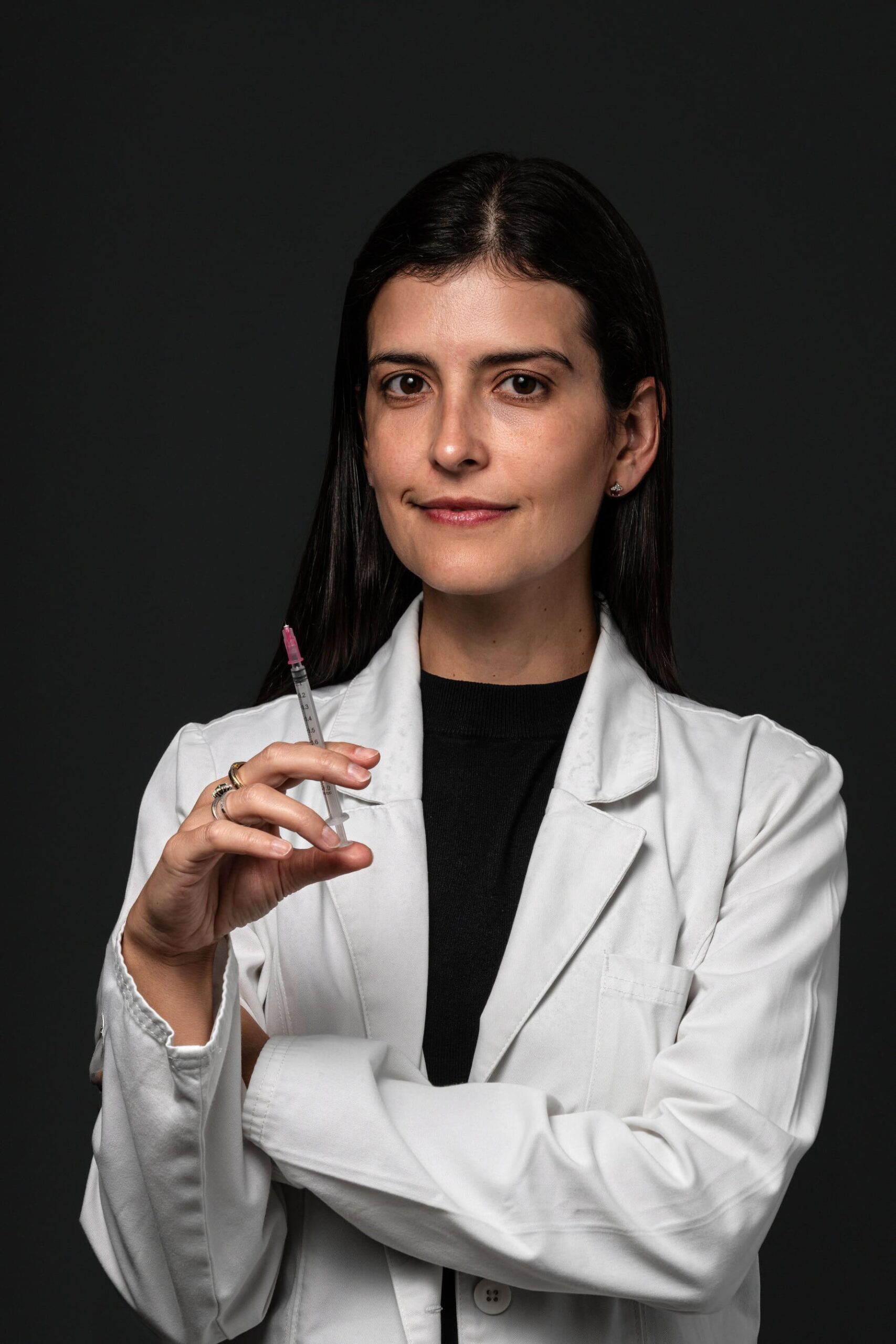 Neuróloga de Neuro+ con jeringa para aplicación de toxina botulínica
