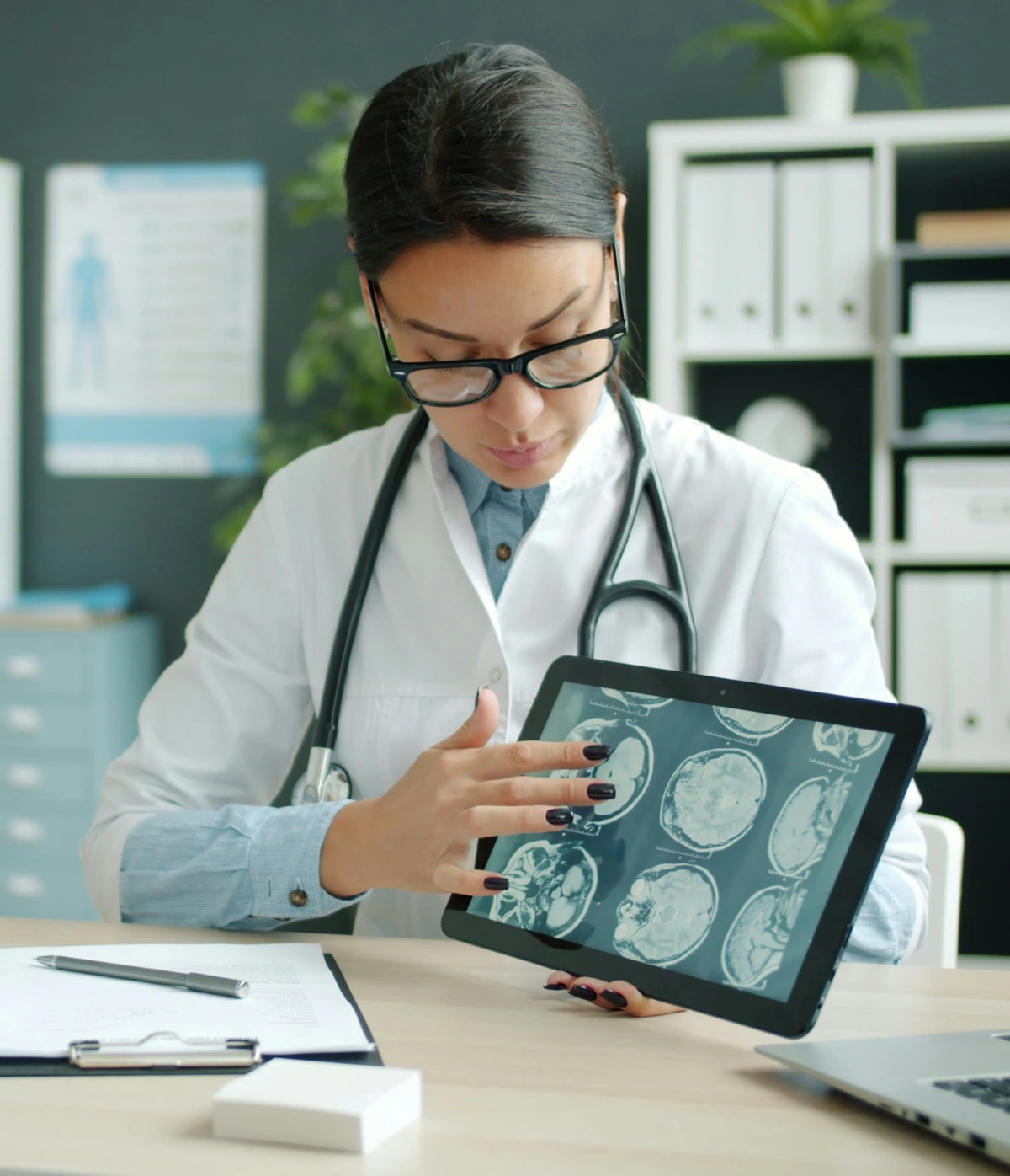 Neuróloga revisando una resonancia cerebral durante una consulta neurológica por Parkinson